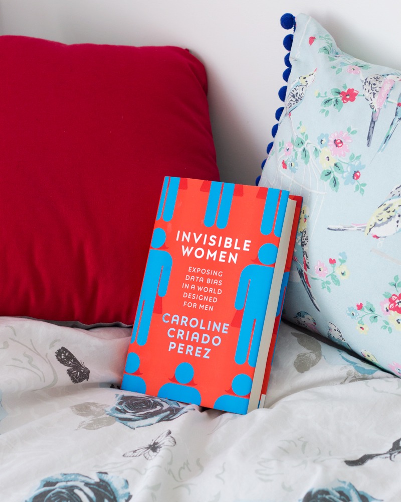 Invisible Women by Caroline Criado Perez - book propped up on a bed with bird pillow and bedding