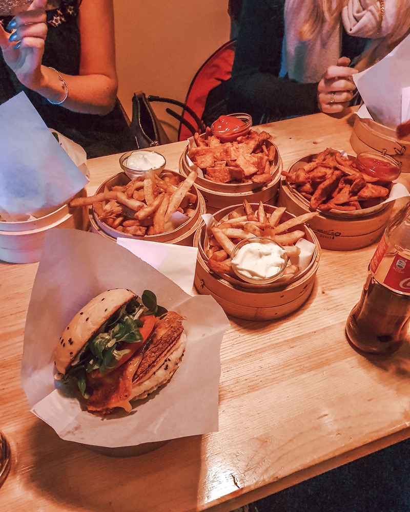 Dinner at Shiso Burger in Mitte, Berlin. In the foreground is Sam's tofu burger, while bowls of chips and sweet potato fries sit in the centre of the table, waiting to be shared.